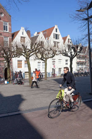 young man on bicycle on spui square in centre of amsterdam on sunny winter dayのeditorial素材