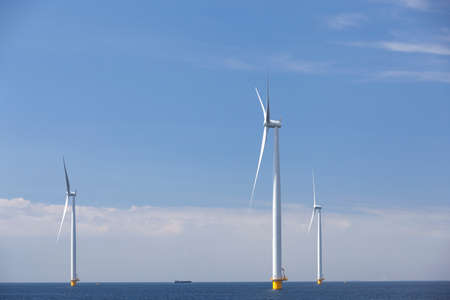 wind turbines in water of ijsselmeer off the coast of flevoland with blue sky in the netherlandsの写真素材