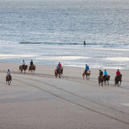 girls on icelandic horses on north sea beach of dutch island vlielandの写真素材
