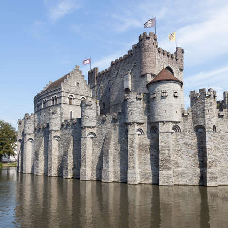 castle Gravensteen in the Beldian city of Ghent with reflection in in river and blue skyのeditorial素材