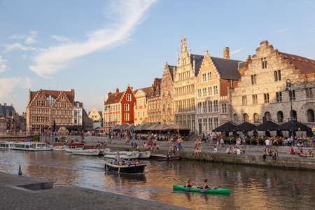 canoe and boats in river Leie in medieval centre in belgian town of ghent at sunsetのeditorial素材