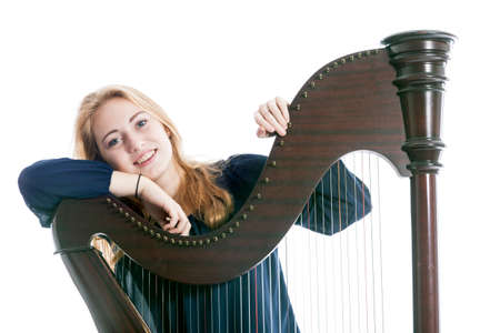 red blond caucasian teenage girl leans on harp against white studio backgroundの写真素材