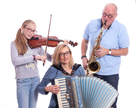 musical family plays saxophone, violin and accordion in studio against white backgroundの写真素材