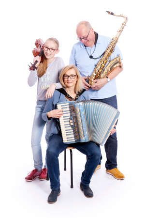 musical family with saxophone, violin and accordion in studio against white backgroundの写真素材