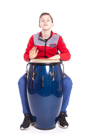 teenage caucasian plays the conga in studio with white background