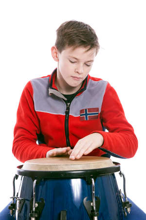 teenage caucasian plays the conga in studio with white backgroundの写真素材