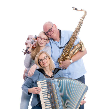 musical family with saxophone, violin and accordion hugs in studio against white backgroundの写真素材