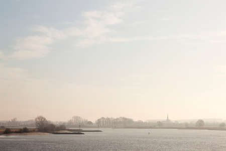 part of river Lek ands silhouette of dutch town Lexmond in province of South-Holland in the netherlandsの写真素材