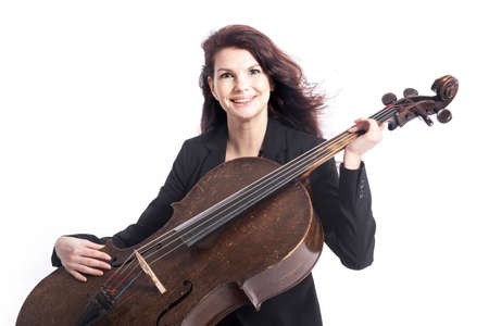 beautiful brunette woman holds old brown violoncello in studio against white backgroundの写真素材