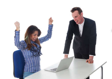 secretary with laptop at table and boss seem happy with result in studio against white background and she is cheeringの写真素材