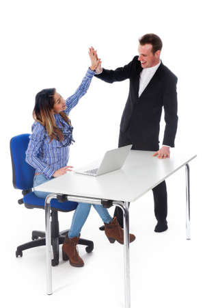 secretary with laptop at table and boss seem happy with result and give high five in studio against white backgroundの写真素材