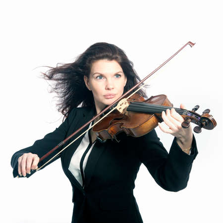 classical brunette beauty in suit plays the violin in studio against white backgroundの写真素材