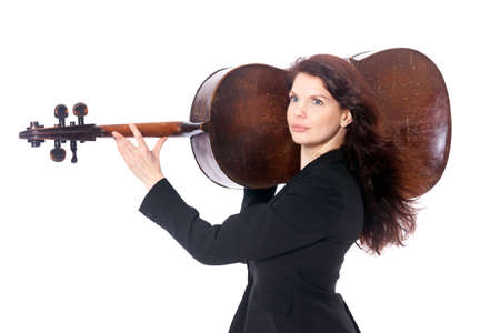 beautiful brunette woman carries old brown violoncello on shoulder in studio against white backgroundの写真素材