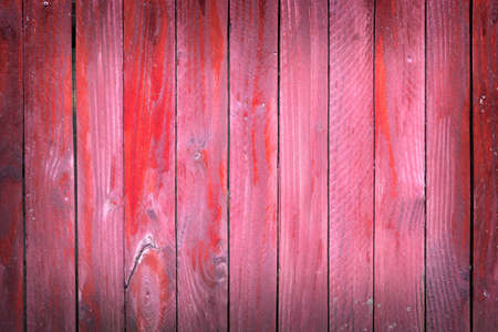 vertical planks of faded red painted worn planks on horizontal piece of fence or doorの写真素材