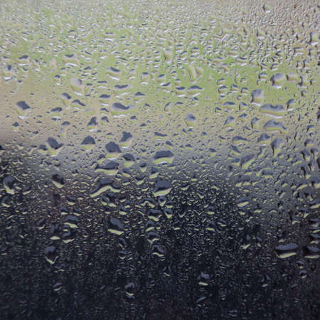 rain drops on windshield of car and background in several colorsの写真素材