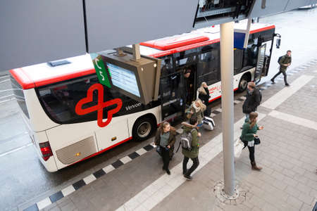 passengers at utrecht station near syntus bus on rainy day in the netherlandsのeditorial素材
