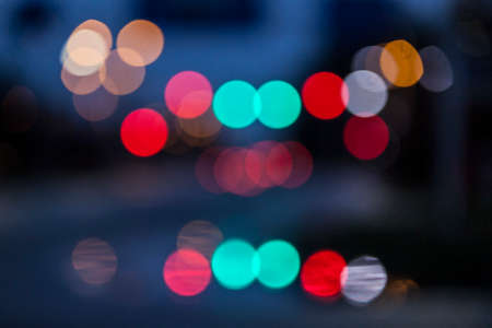 abstract traffic lights in many colors out of focus against black blue backgroundの写真素材