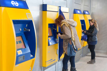 Utrecht, Netherlands, 15 march 2017: women buy tickets at machine on utrecht central station in the netherlandsのeditorial素材