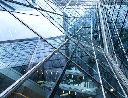 abstract pattern of lines and sky reflecting glass facades of modern steel corporate buildingの写真素材