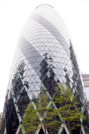 London, United Kingdom, 7 may 2017: contrasting green spring trees against steel and glass of gherkin building in the city of londonのeditorial素材