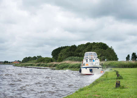 Docked yaught on lake near Sneek in dutch province of Friesland during summer stormの写真素材