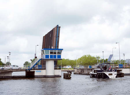 boat in european cultural capital 2018 Leeuwarden enters open drawbridge in the dutch province of frieslandのeditorial素材