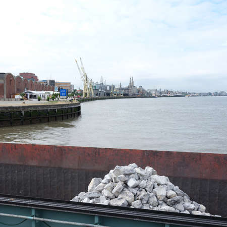 ship loaded with natural stone enters harbor on river Schelde in antwerp