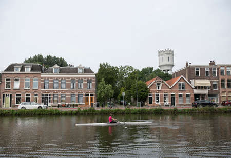 Delft, netherlands, 30 june 2017: delftse schie and woman in canoe in dutch town of delftのeditorial素材