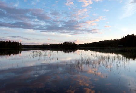 lake and forest in saima area in finland at sunsetの写真素材