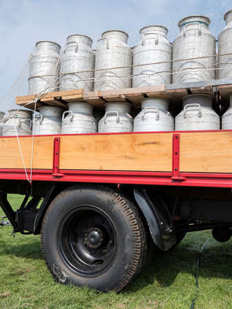 milk churns on old vintage truck against blue sky backgroundの写真素材
