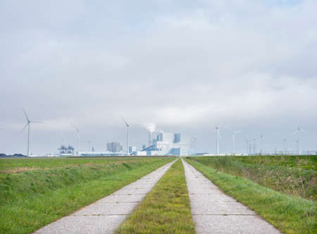 power plant and wind turbines behind field at Eemshaven in the north of groningen in the netherlandsの写真素材