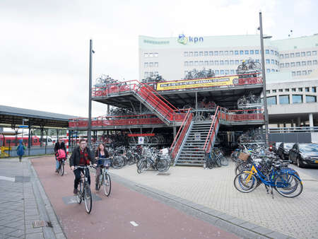 groningen, netherlands, 8 oktober 2017: people pass bicycle storage at central railway station groningen in the north of  the netherlandsのeditorial素材