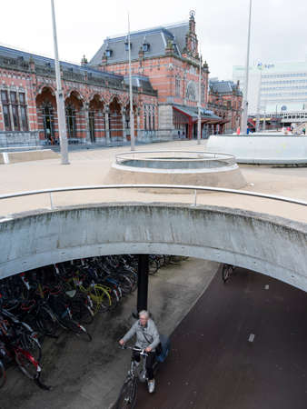 bike on bicycle track under square in front of central railway station groningen in the north of  the netherlandsのeditorial素材
