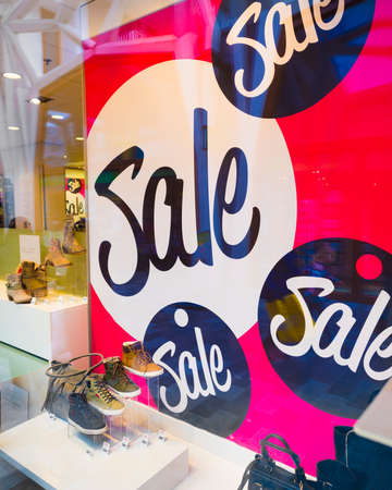 Big letters indicate sale in shop windows of shoe storeの写真素材