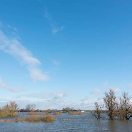 flooded flood plains of river ijssel and ship near Zalk between Kampen and Zwolle in the netherlandsの写真素材