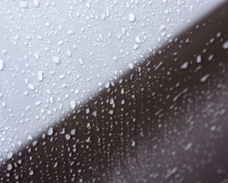 rain droplets on surface of white car body after showerの写真素材