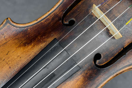 part of violin with f hole against gray backgroundの写真素材