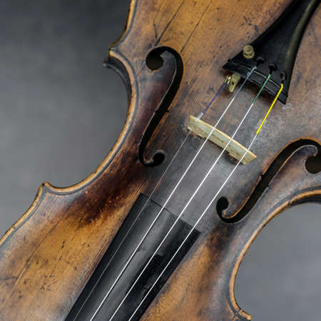 part of violin with f hole against gray backgroundの写真素材