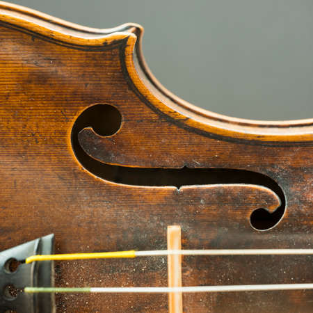 square part of violin with f hole and snares against grey backgroundの写真素材
