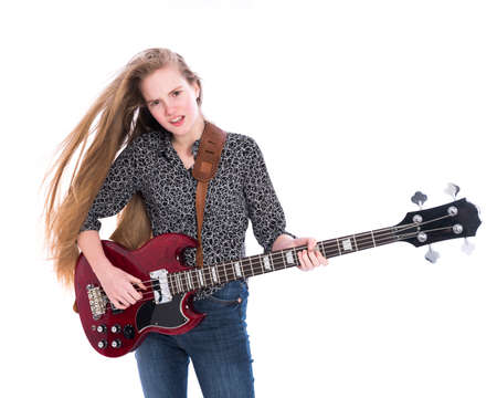blond pretty teen girl and red bass guitar against white background in studioの写真素材