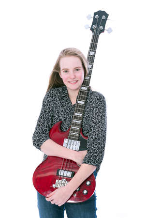 blond pretty teen girl and red bass guitar against white background in studioの写真素材