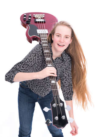 blond pretty teen girl and red bass guitar against white background in studioの写真素材