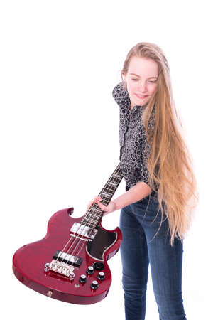 blond pretty teen girl and red bass guitar against white background in studioの写真素材