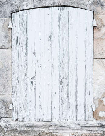 background consisting of light grey or white old shutters in limestone wall of french provence houseの写真素材