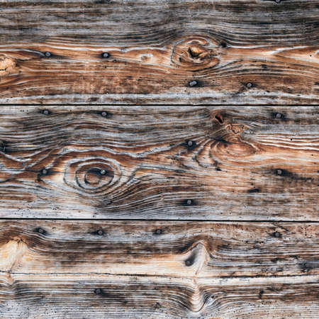 closeup of old worn out black and brown wooden planksの写真素材