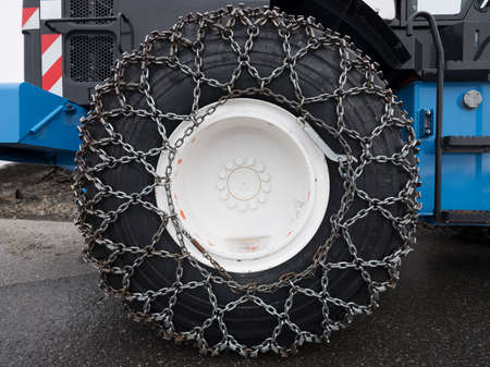 snow chains around large wheel of bulldozerの写真素材