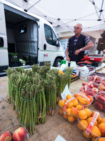 Briancon, France, 10 july 2018: green asparagus and peaches on market in briancon in the french alps of haute provenceのeditorial素材