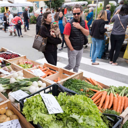 briancon, france, 10 june 2018: man and woman look at vegetables on open air market of briancon in the french haute provenceのeditorial素材