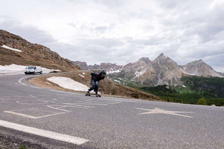 col dizoard, france, 10 june 2018: person on skateboard leaves col dizoard in the french alps of...