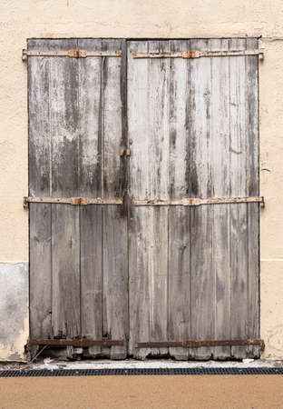 very old weathered grey doors in ancient wall of medieval village in french provenceの写真素材